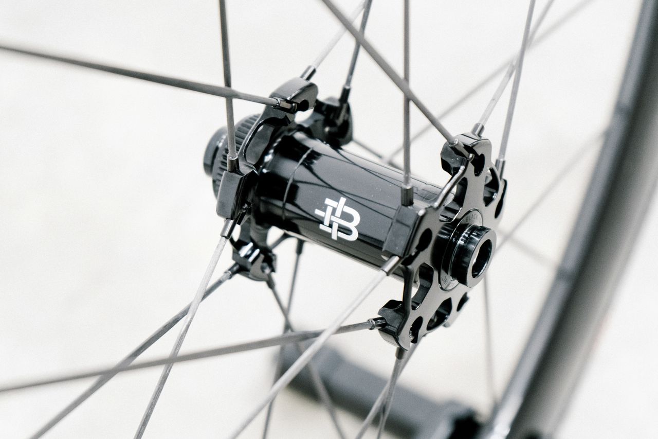An aero road wheel stands against a white wall