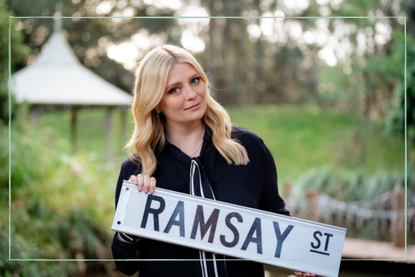 Misha Barton (Reece Sinclair) holding Ramsay Street sign