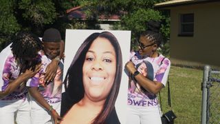 Ajike 'AJ' Owens' sons, Israel and Isaac, and her mother Pamela Dias hold a picture of Owens at a ceremony to honor the one-year anniversary of her murder.