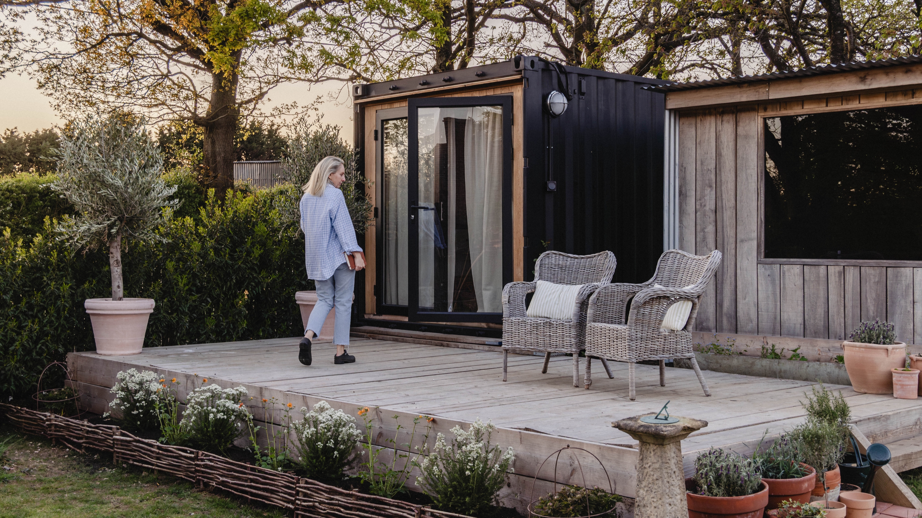 an outdoor garden room with a patio made from a shipping container 