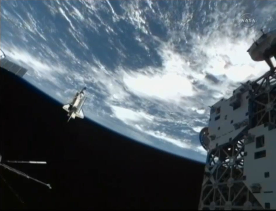 Space shuttle Discovery is seen in cameras as it flies around the International Space Station after undocking for the final time on March 7, 2011 during its last mission, STS-133.