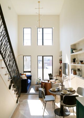 Open plan small living room with large windows and double height ceilings