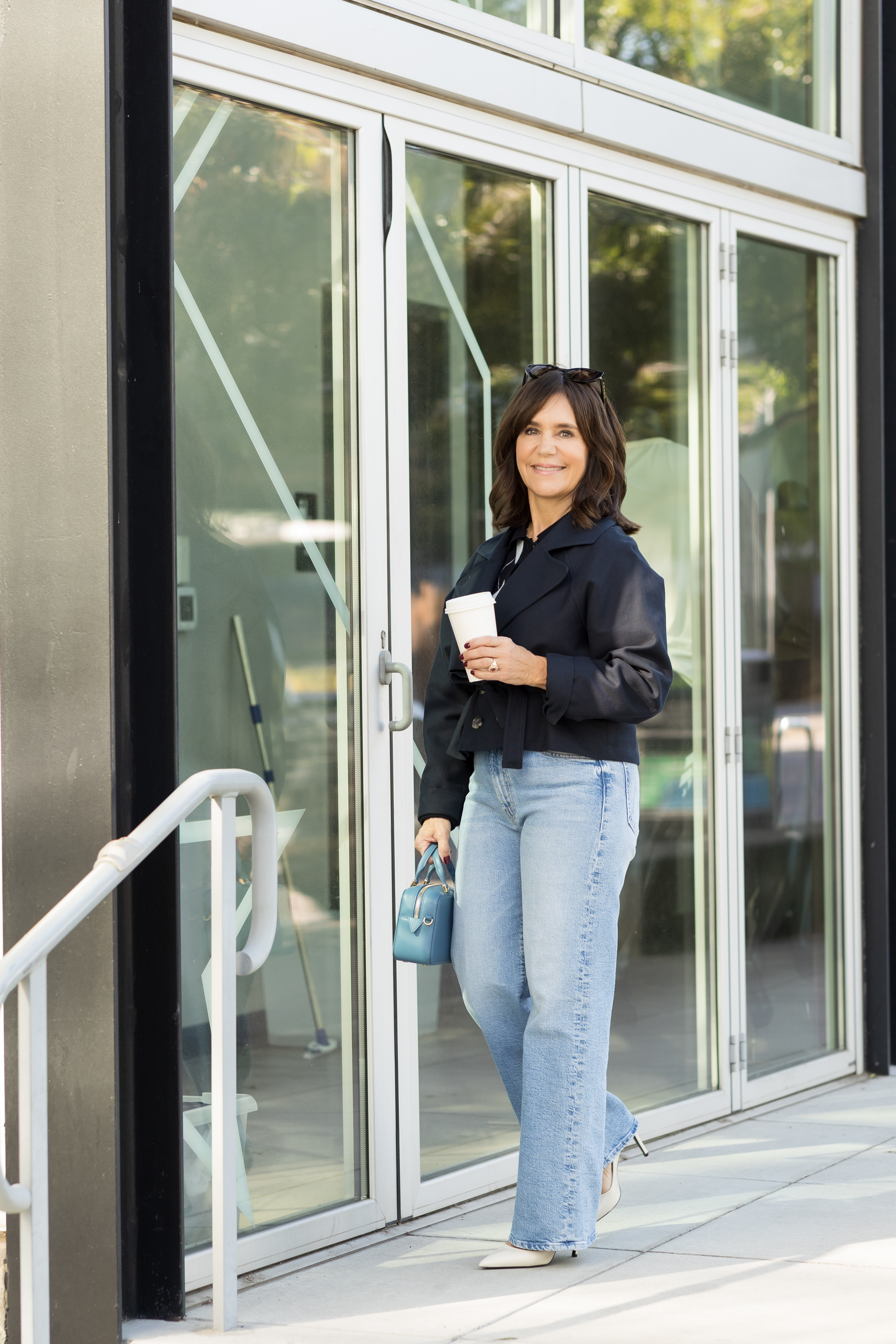 A former Nordstrom buyer wearing a cropped jacket and light-wash, straight-leg jeans.