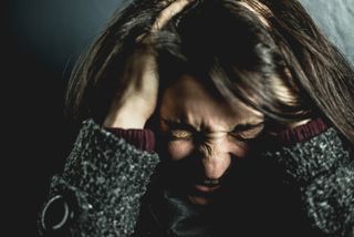 Upset woman with head in hands