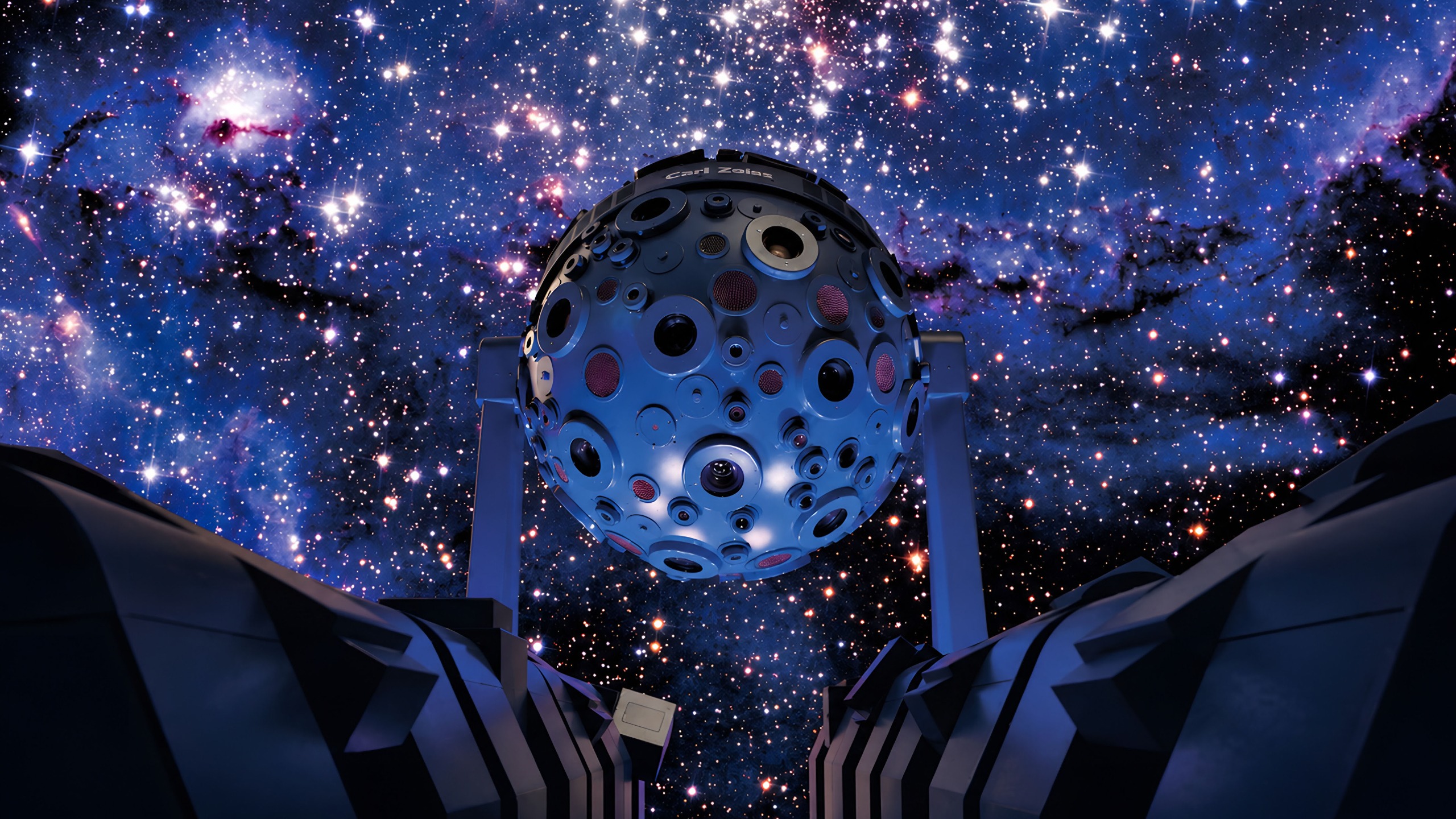An immersive planetarium with stars on the sky of a domed screen.