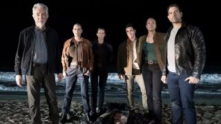 The cast of Criminal Minds: Evolution season 18 stand over a body on a beach