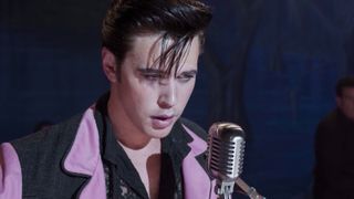 Austin Butler as Elvis Presley singing into a microphone.