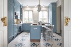 A kitchen with blue cabinets and island
