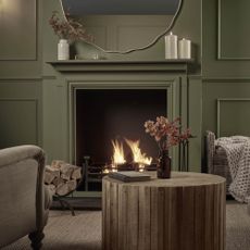 living room with green painted wood panelling and fireplace