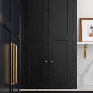 Black painted kitchen cabinets with gold hardware handles