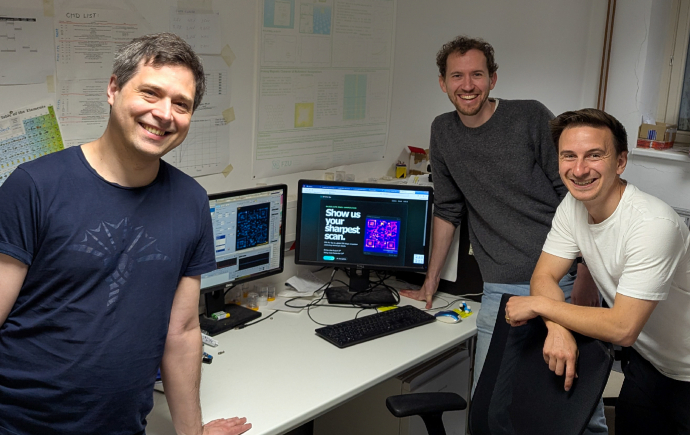 Monash University School of Physics and Astronomy researchers stood next to the photo of their record breaking QR code.