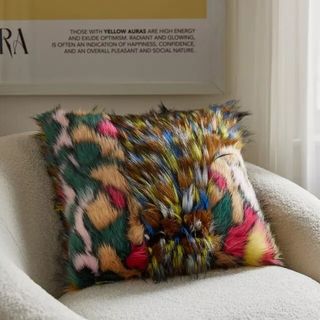 Fuzzy colorful pillow on chair