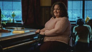 Martha Scott sitting at the bar of a pub and smiling in Baby Reindeer.