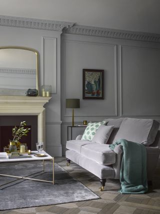 grey living room with panelled walls and grey velvet sofa by sofa.com