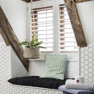 Cushion with white walls white windows and hanged potted plant