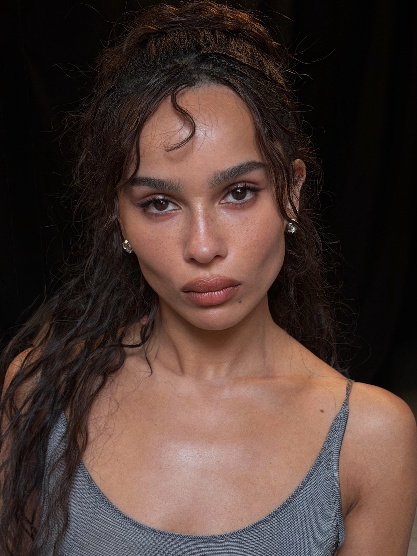 zoe kravitz with a grey slinky dress on and braided half up half down hair