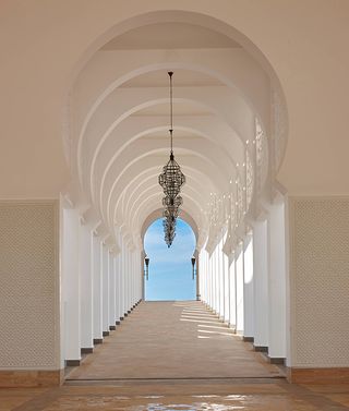 Exterior walkway of the Banyan Tree Tamouda Bay with large white stone archways