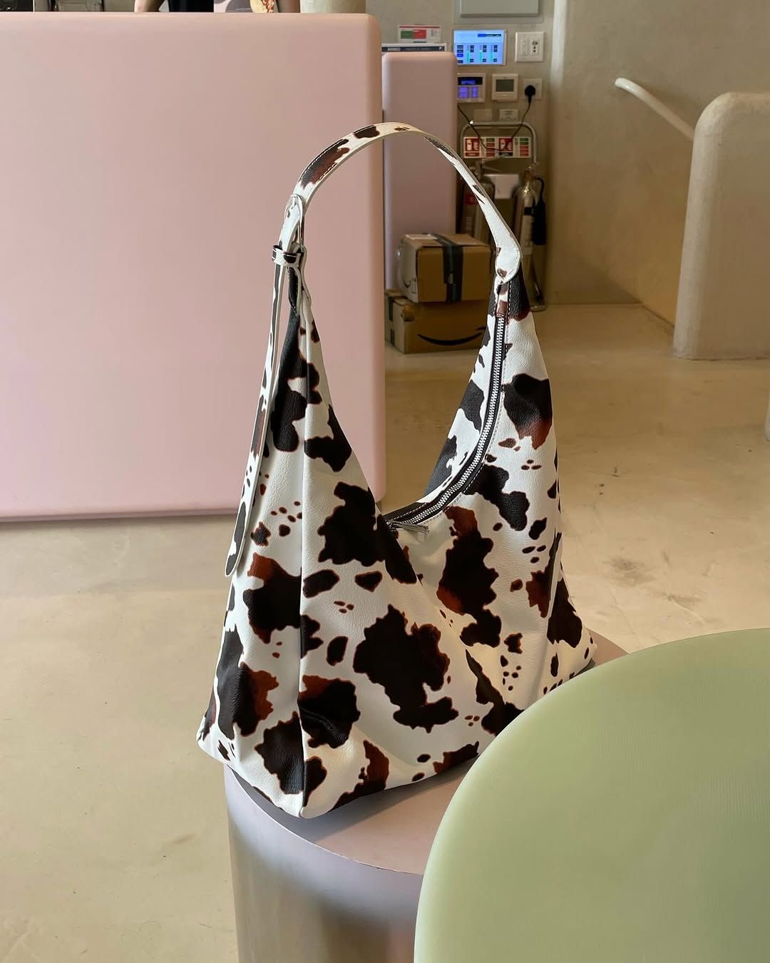 Dark brown and white cowprint shopping bag with with silver zip detailing.