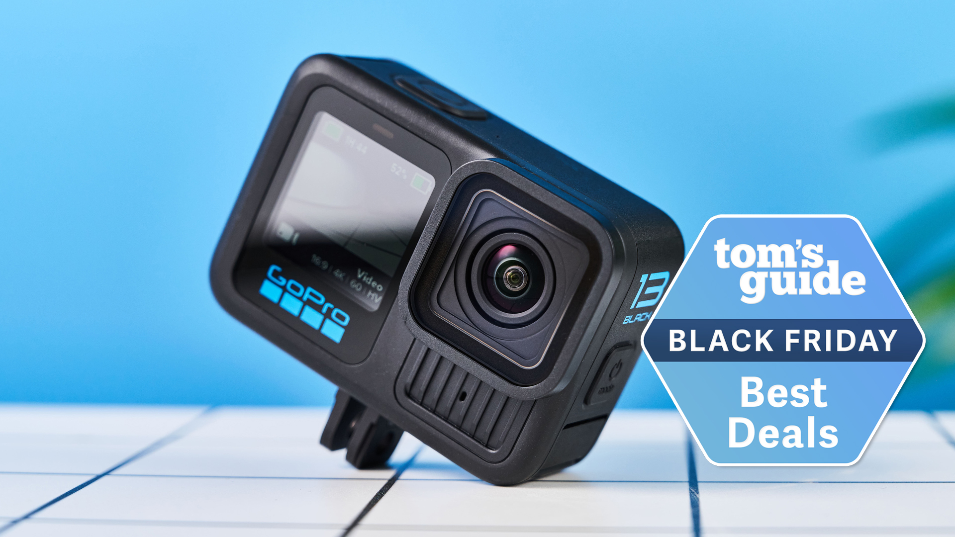 The GoPro Hero13 Black on a white tabletop with a blue background. A Tom&#039;s Guide Black Friday deal badge is in the bottom right of the image