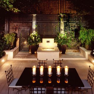 garden dining area at night time with lighting and candles