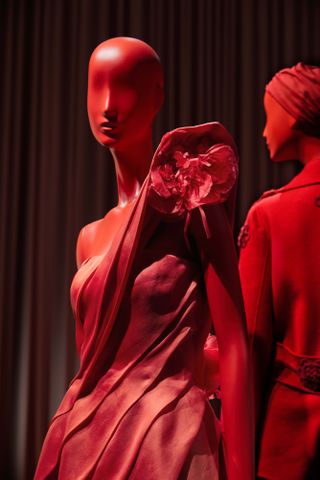 Two red mannequins in red Valentino dresses in exhibition