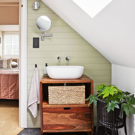 Green bathroom with wooden vanity and vessel basin