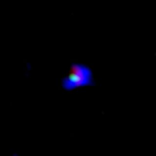 A close-up view of the ancient galaxy SXDF-NB1006-2, showing ionized oxygen (in green) as seen by the ALMA radio telescope, and ionized hydrogen (in blue) seen by the Subaru Telescope. Ultraviolet light detected by the UK Infrared Telescope is shown in red.