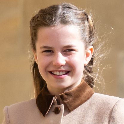 Princess Charlotte wearing a brown coat and smiling