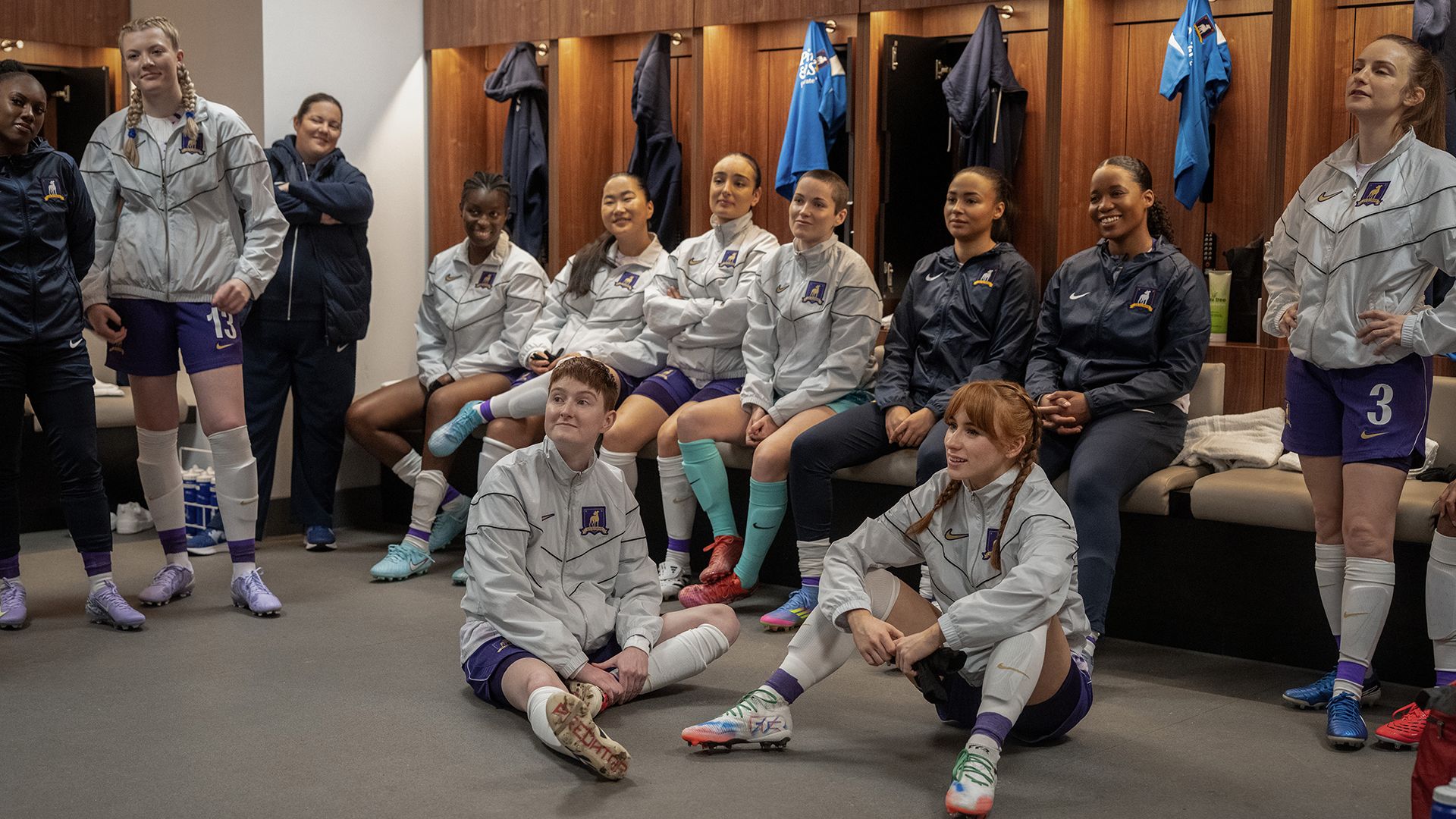 Members of AFC Richmond Women sitting on the floor and on benches in Ted Lasso season 4 episode 9
