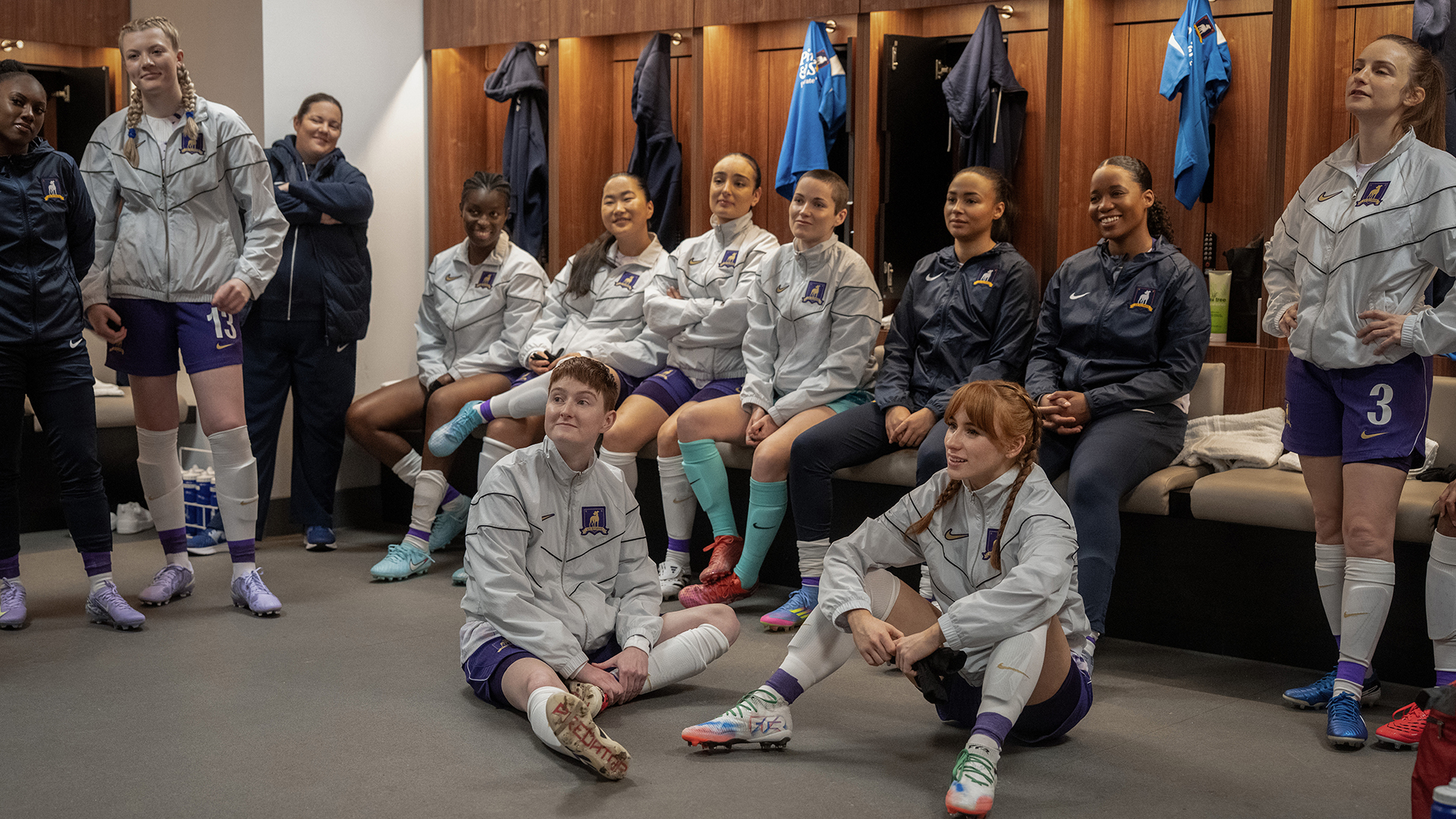 Members of AFC Richmond Women sitting on the floor and on benches in Ted Lasso season 4 episode 9