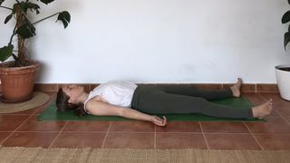 Yoga teacher reclining on mat