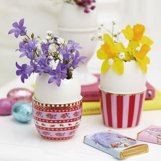 eggshell vase with egg cups yellow flower and side table