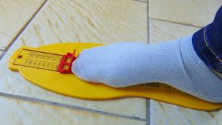 Yellow foot measurement device with foot being measured
