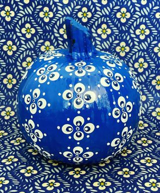 Pumpkin decorating idea with blue paint decor and white clover motif