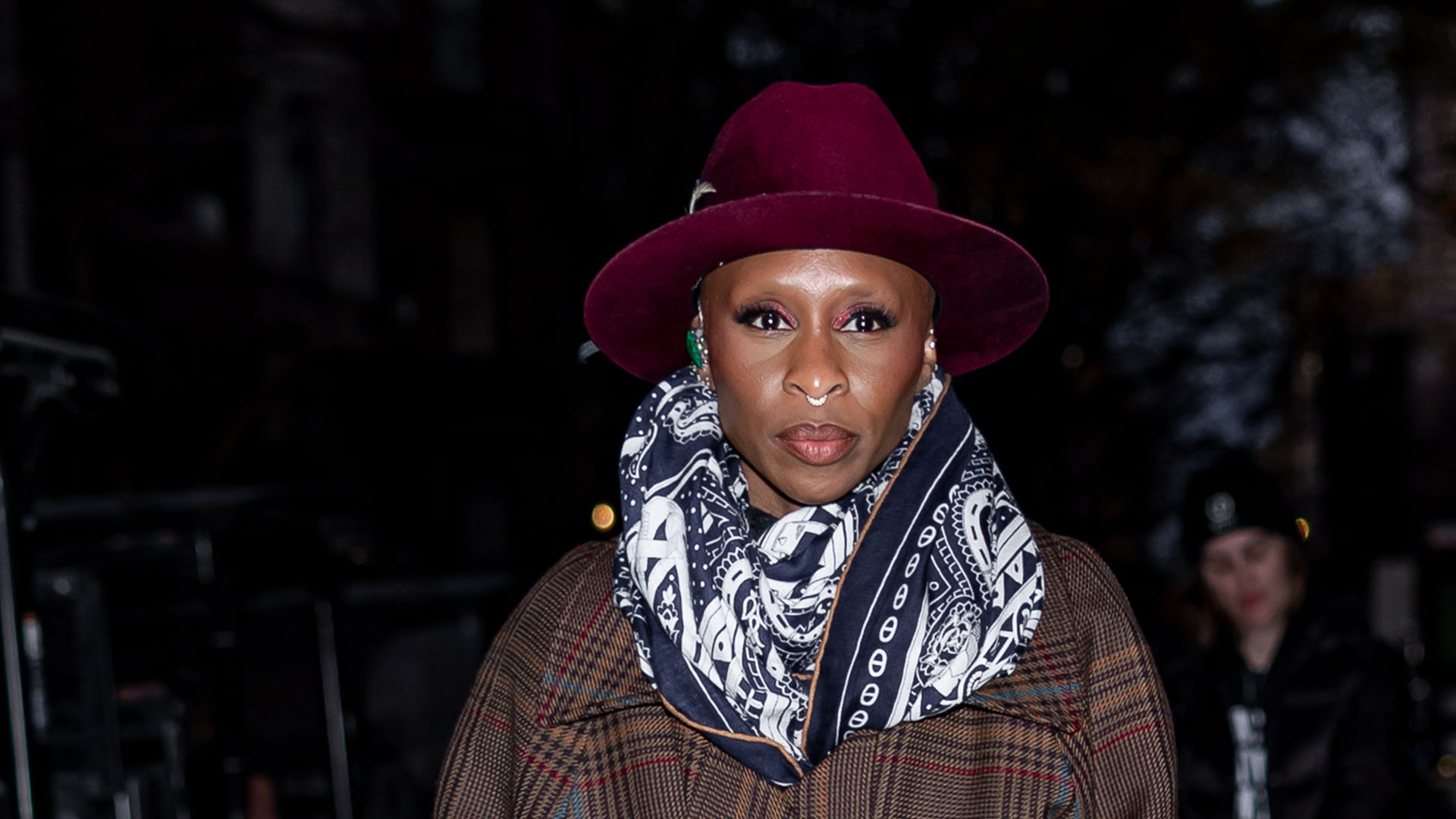 Cynthia Erivo wearing a trench coat and white boots