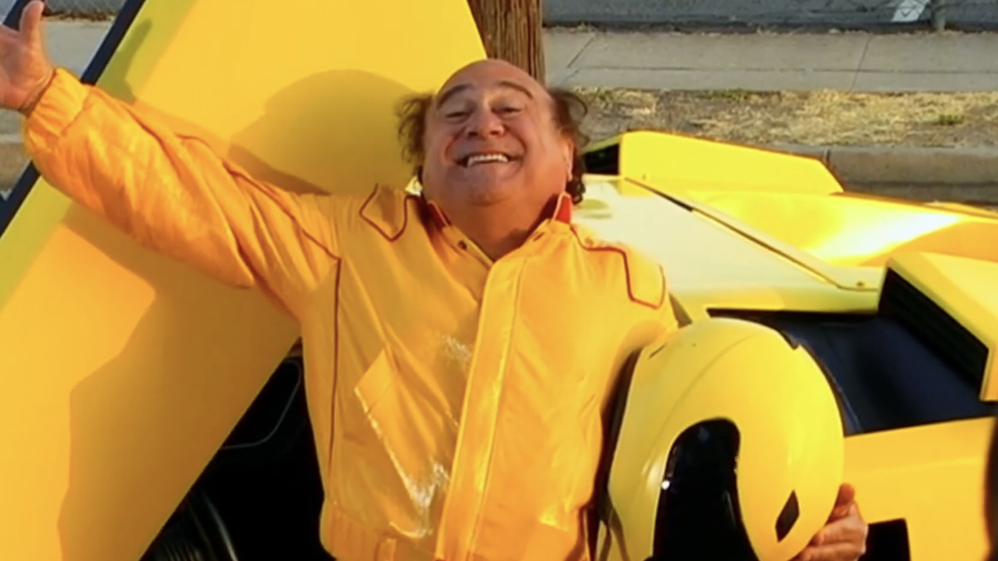 Frank holding helmet standing next to yellow Lamborghini Countach in It's Always Sunny in Philadelphia Christmas episode