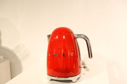 A red SMEG kettle on a worktop