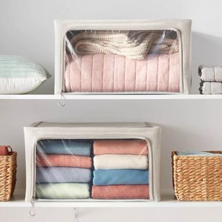Fabric storage bags filled with folded pastel hued garments in closet