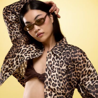 Model wearing a black braletter with a leopard print jacket and sunglasses sold at Coggles