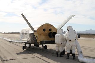 A recovery team processes the U.S. Air Force's X-37B space plane after the robotic spacecraft's successful landing at Vandenberg Air Force Base in California on Oct. 17, 2014. The touchdown marked the end of the X-37B’s third space mission.