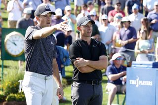 Jordan Spieth and Rory McIlroy point to where the ball went in at TPC Sawgrass