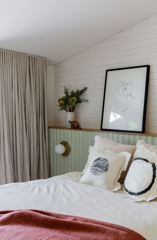 A bedroom with pistachio headboard and pink bedding