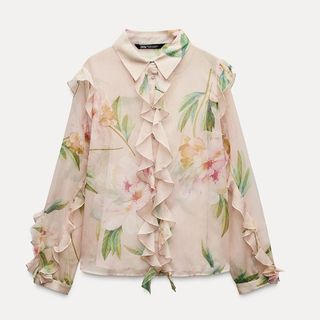 A cut out image of a pink Zara floral blouse with ruffles on a white background