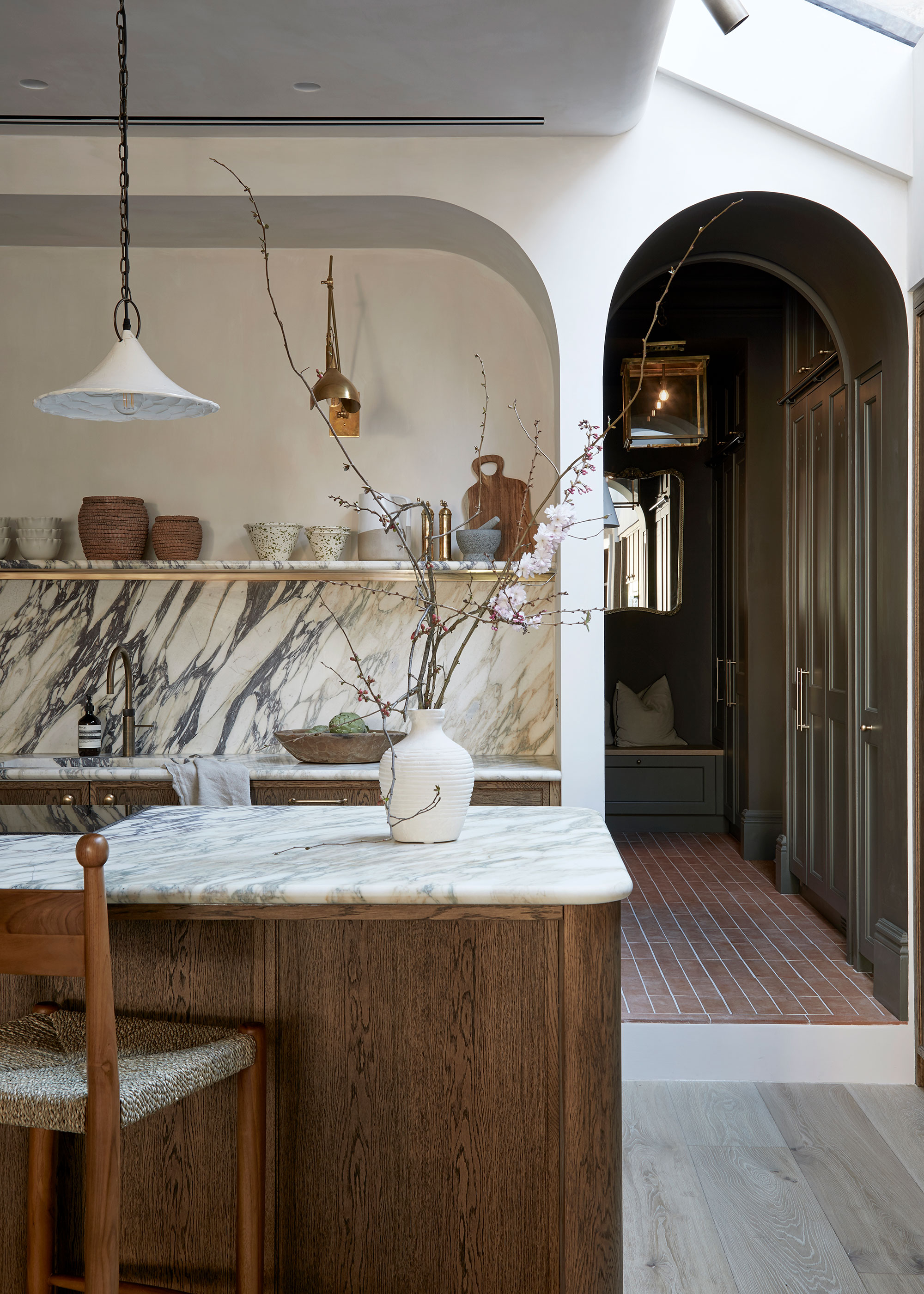 dark wooden kitchen with marble worktops and splashbacks