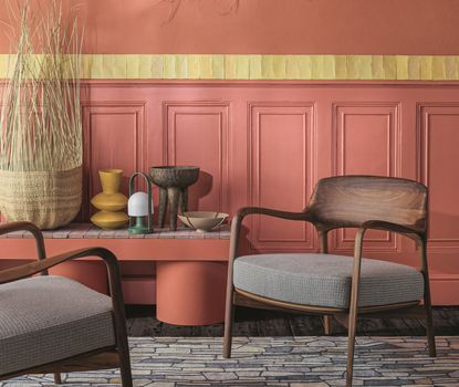 A mid century modern style living room with panelled walls painted in a terracotta colour
