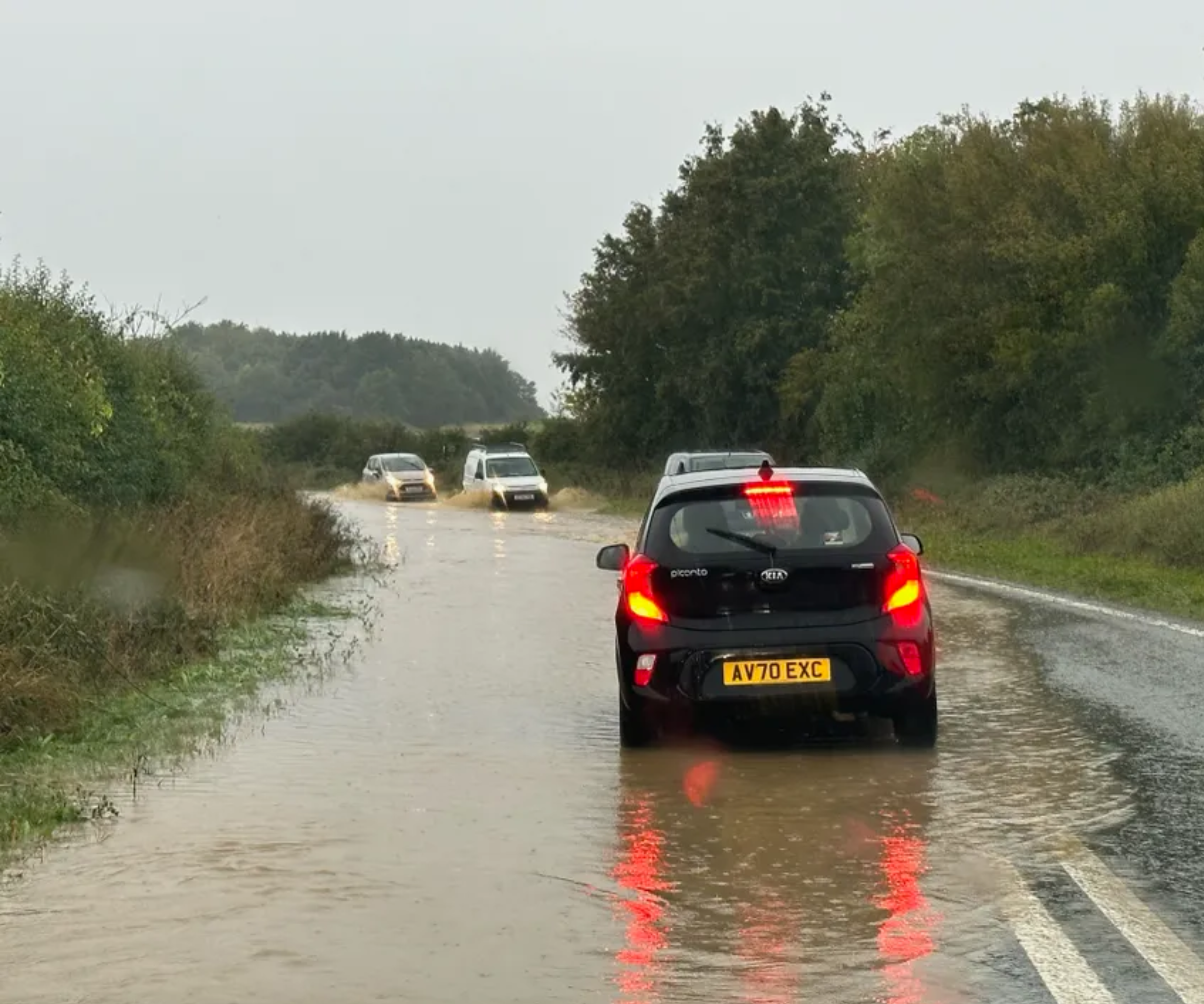 Flooding on a country road with cars in the middle