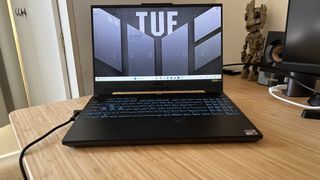 Asus TUF A15 gaming laptop open on a wooden desk