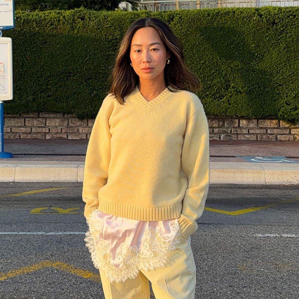 a woman wearing a butter yellow sweater over a lace-trim top, and butter yellow pants