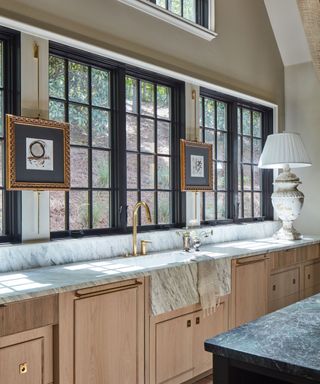 kitchen prep area with pale wood cabinets and arched window wall