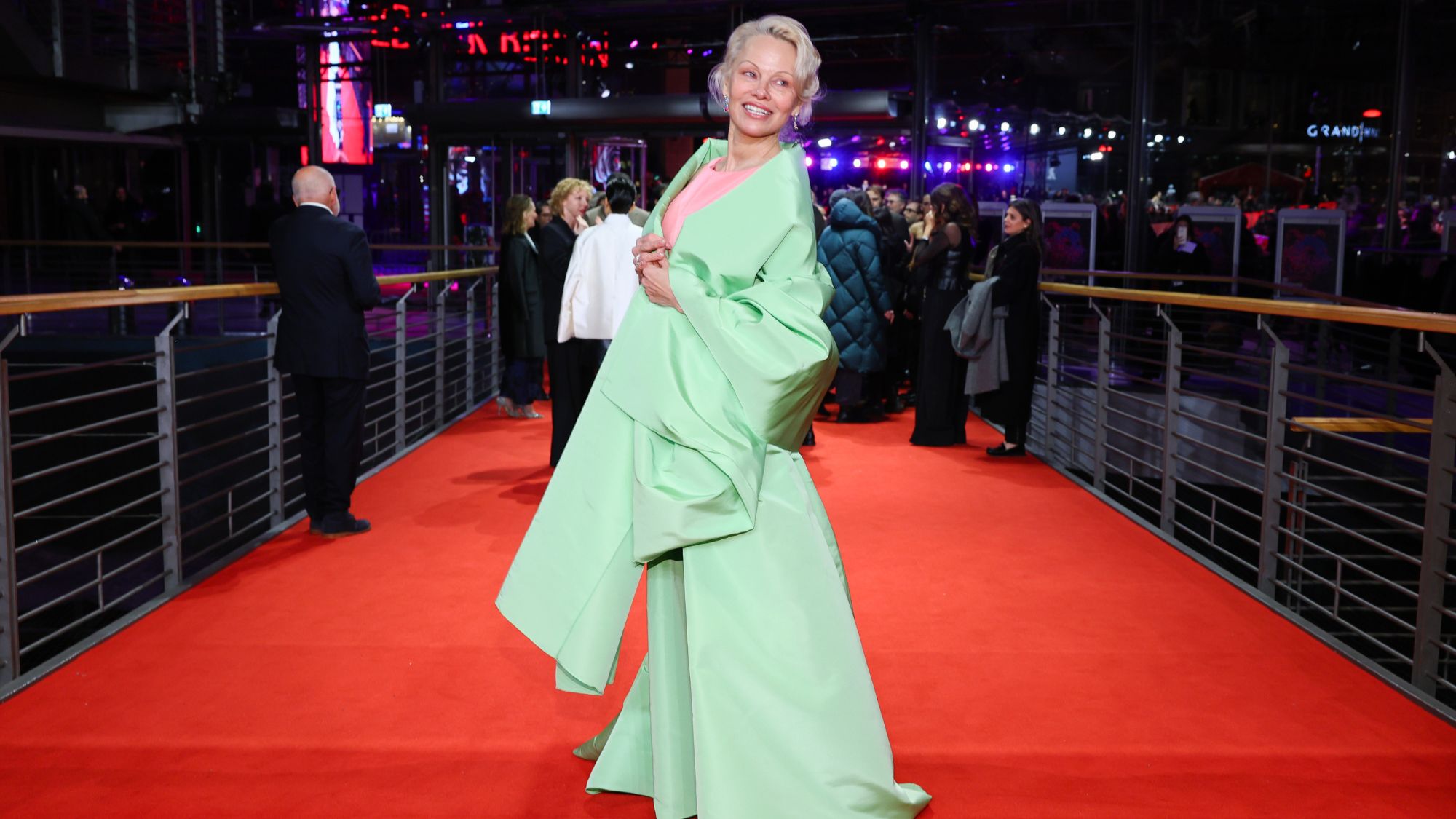 pamela anderson wears a pink and green look at the berlinale red carpet
